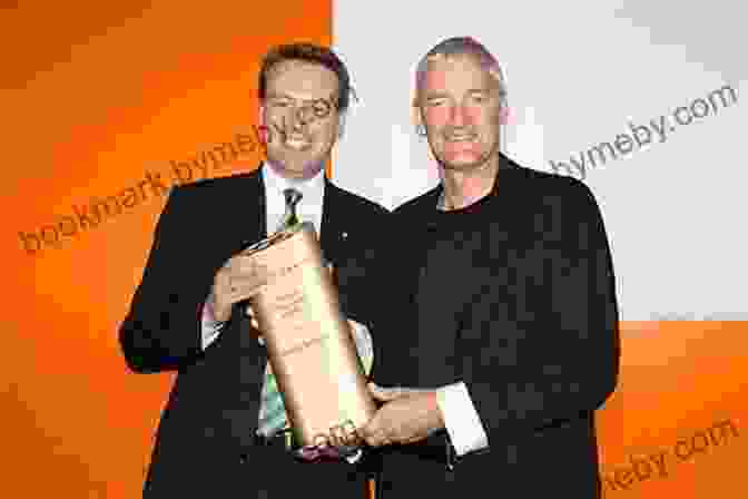 A Photograph Of James Dyson Receiving An Award, Dressed In A Suit And Tie, Holding The Award With A Smile. Invention: A Life James Dyson